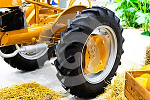 Small yellow tractor in exhibition, closeup details, wheels