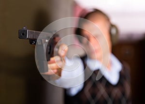 Smallbore sporting pistol in hand of man training in shooting range