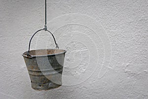 smallold rusty metal bucket hanging on a string
