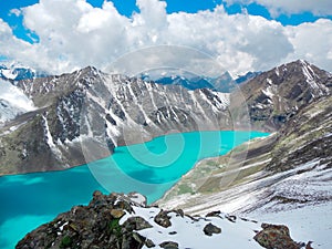 Smaragd water of misty Ala Kul lake in Terskey Alatoo mountains, Karakol national park, Kyrgyzstan photo