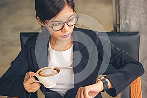 Smart Asian business woman holding mocha latte art coffee.