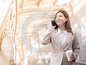 Smart asian business woman in a suit with mobile phone.