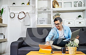 Smart Asian businessman is working on computer laptop and tablet , SME start up concept, work from home