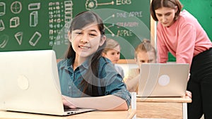 Smart asian girl looking at camera while coding engineering prompt. Pedagogy.