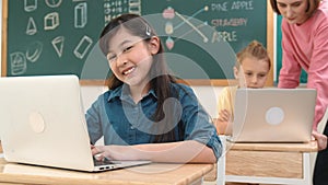 Smart asian girl looking at camera while coding engineering prompt. Pedagogy.