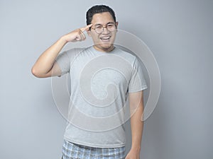 Smart Asian Man Pointing on His Head and Smile
