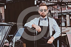 Smart barista in glasses has a break at his own coffeeshop.