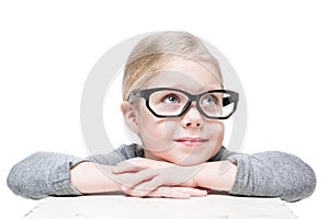 Smart beautiful little girl in glasses looking on something