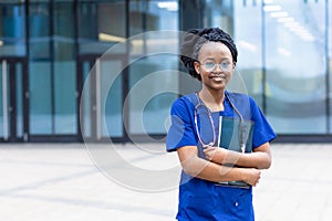 Smart black girl medical student in glasses, happy young african american woman doctor, nurse in blue uniform, stethoscope