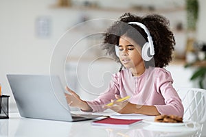 Smart black girl schooler having video call with teacher