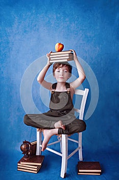 Smart blond kindergarten boy with a piles of books. Back to school, Preschool, Early education