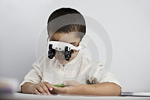 A smart boy with headband magnifying glass