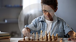 Smart boy playing chess carefully thinking through each move, logical game