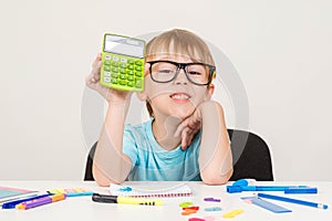 Smart boy using calculator. Kid in glasses figuring out math problem. Developing logical skills. Happy school boy doing homework.