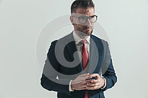 Smart businessman in his forties touching hands and paying attention