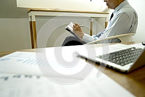 Smart businessman sitting happily thinking on a chair warm tone