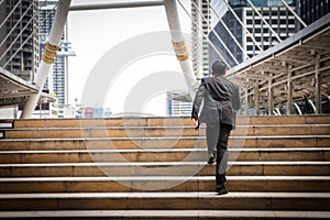 Smart Businessman is walking on the steps and heading to his goa