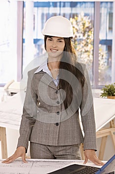 Smart businesswoman wearing hardhat smiling