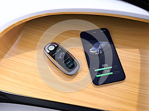 Smart car key and smart phone on electric car`s dashboard