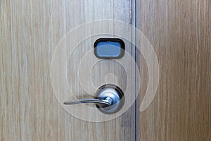 Smart card door key lock system in hotel. Hotel electronic lock on wooden door. Entrance door with electronic card lock security.