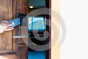 Smart card door key lock system in hotel. Hotel electronic lock on wooden door. Entrance door with electronic card lock security.