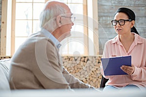 Smart caregiver examining senior man