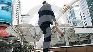 Smart caucasian businessman walking up stairs surrounded by urban view. Urbane.