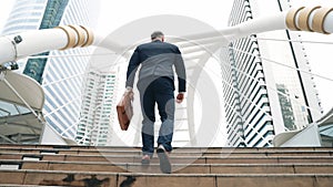 Smart caucasian businessman walking up stairs surrounded by urban view. Urbane.