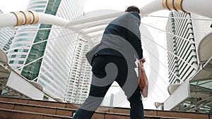 Smart caucasian businessman walking up stairs surrounded by urban view. Urbane.