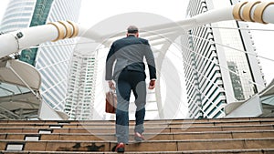 Smart caucasian businessman walking up stairs surrounded by urban view. Urbane.