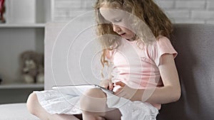 Smart child easily using mobile app on tablet, simple online services on gadget