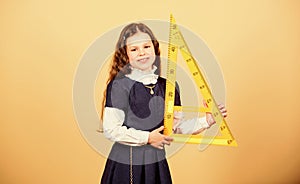 Smart and clever concept. Girl with big ruler. School student study geometry. Sizing and measuring. Kid school uniform