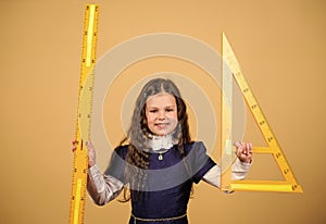 Smart and clever concept. Sizing and measuring. Pupil cute girl with big ruler. School student study geometry. Kid