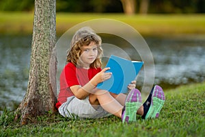 Smart clever Kids. Cute child read books outdoors. Kids learning and summer education. Child boy reading book outdoor on