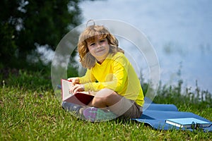 Smart clever Kids. Cute child read books outdoors. Kids learning and summer education. Child boy reading book outdoor on