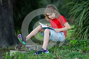 Smart clever Kids. Cute child read books outdoors. Kids learning and summer education. Child boy reading book outdoor on