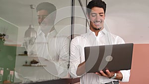 Smart and concentrated hispanic businessman wearing smart casual white shirt using laptop