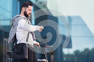 Smart and confident businessman looking at his watch