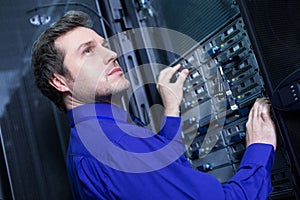 Smart confident man standing in front on the data server