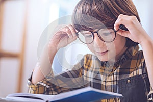 Smart curious boy getting closer look at notes