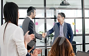 Smart diverse business people wearing formal suits, smiling with happiness, success, making handshake to deal business agreement