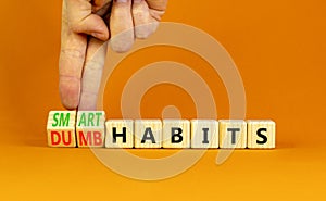 Smart or dumb habits symbol. Concept word Smart habits and Dumb habits on wooden cubes. Beautiful orange table orange background.