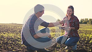 Smart eco farming teamwork using modern technologies in agriculture. farmers man and woman work in the dirt field the