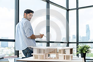 Smart engineer walking around while checking house model construction. Tracery.