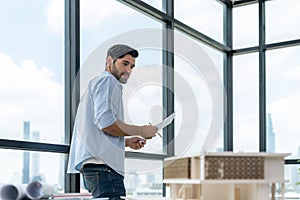 Smart engineer walking around while checking house model construction. Tracery.