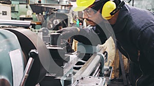 Smart factory worker using machine in factory workshop