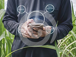 Smart Farming Concept. The farmer is using his mobile phone with Smart farmer technology to control the quality of the farm. Icons