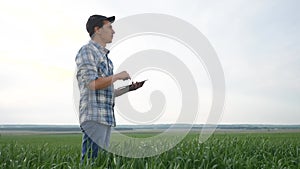 Smart farming. Man agronomist a farmer red neck with digital tablet computer in green wheat field using apps and