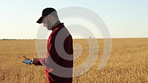 Smart farming using modern technologies in agriculture. Agronomist farmer holds and touch digital tablet computer