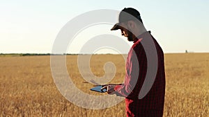 Smart farming using modern technologies in agriculture. Agronomist farmer holds and touch digital tablet computer